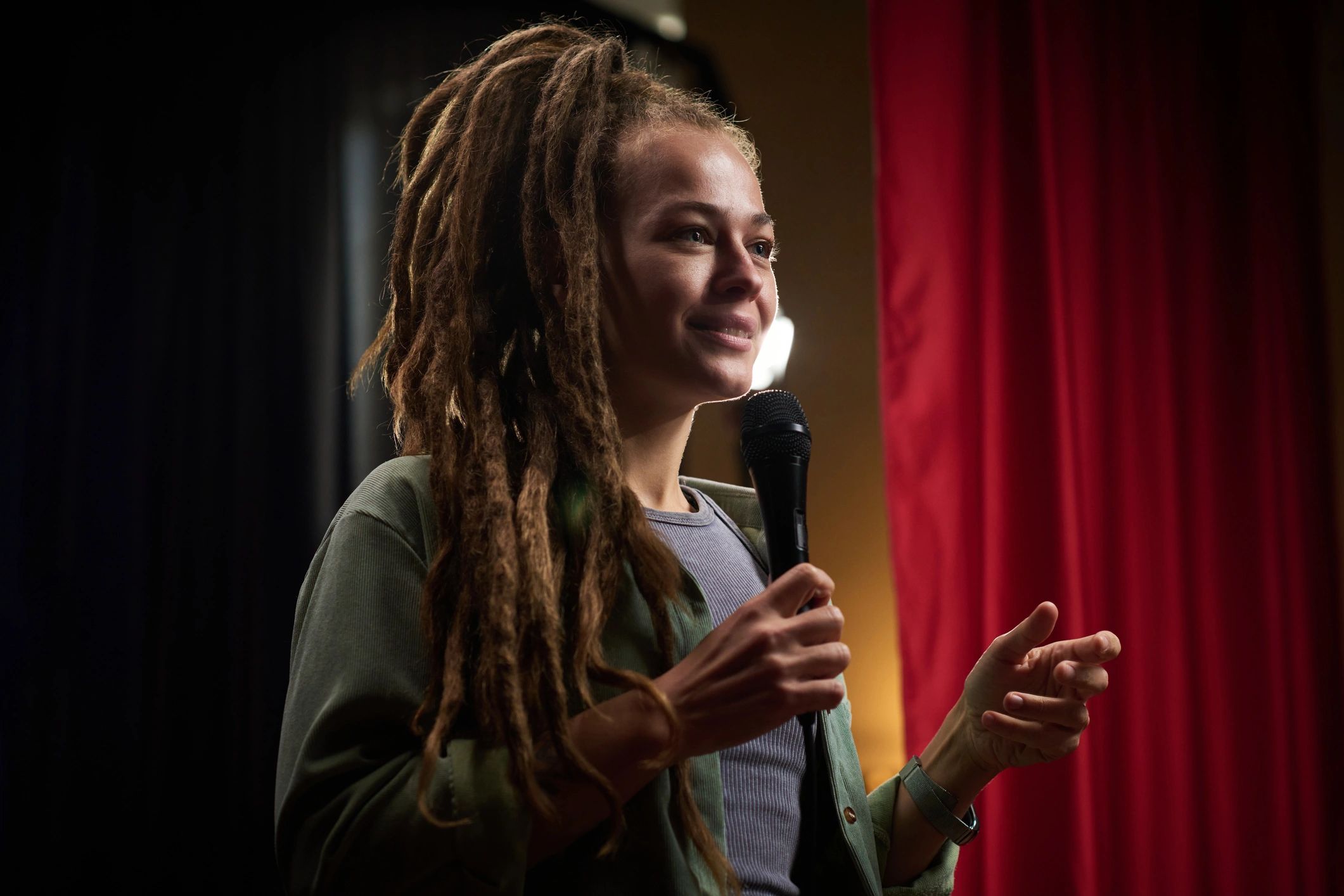 Person speaking into microphone under spotlight