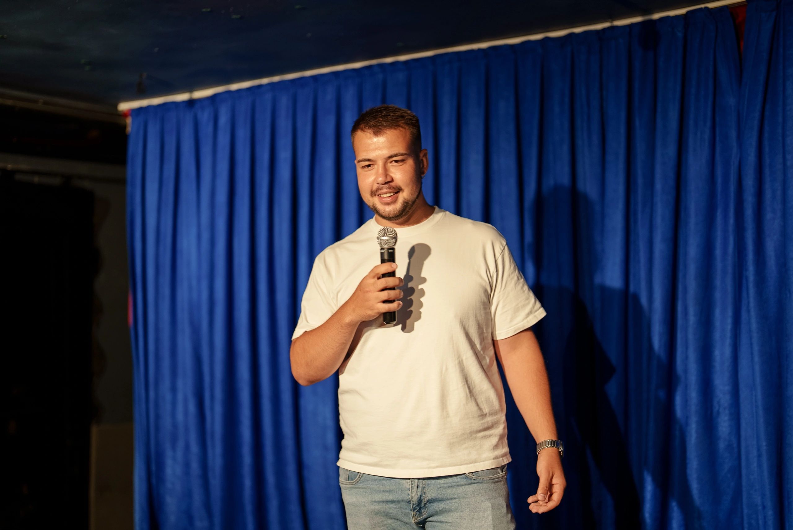 Man holding a microphone and speaking on stage