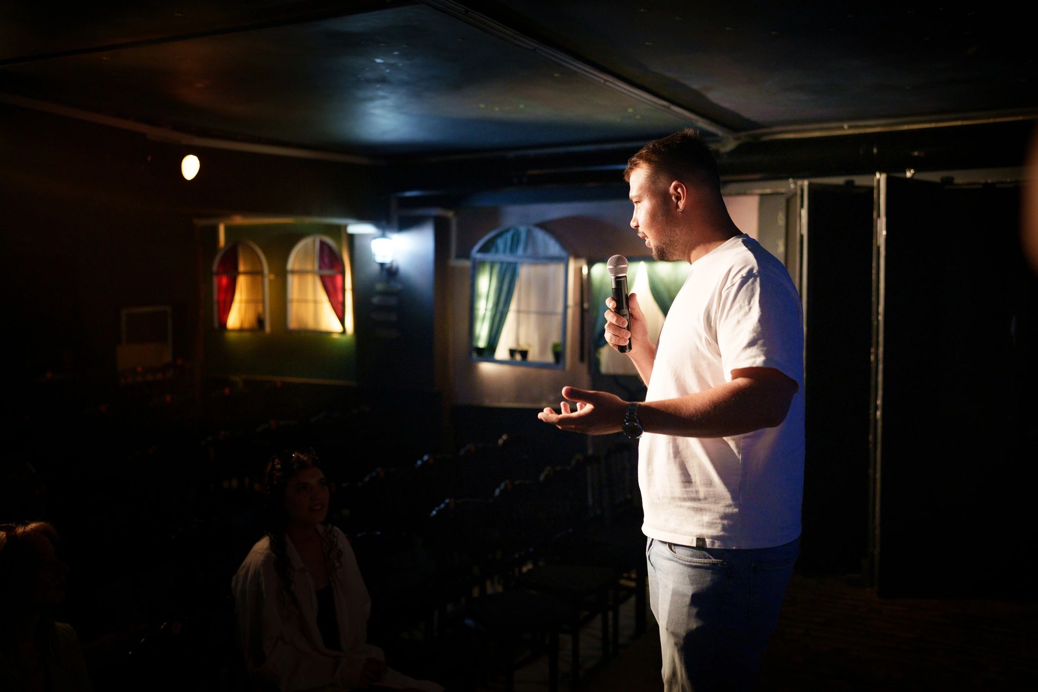 Man speaking with microphone on stage during performance